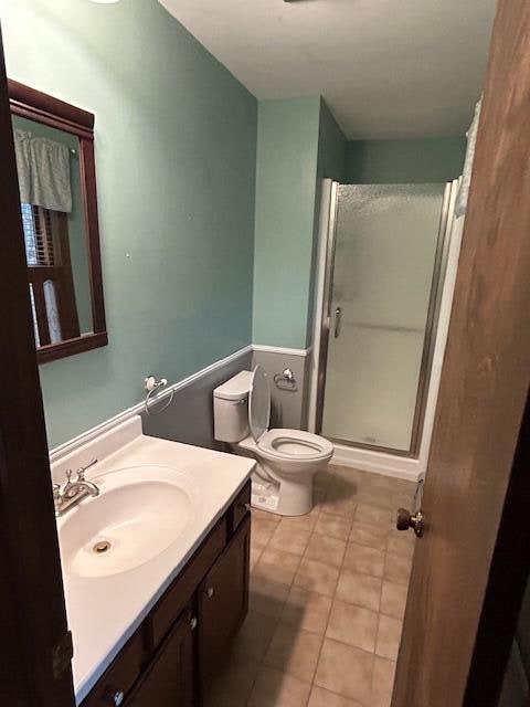 bathroom featuring vanity, toilet, tile patterned floors, and walk in shower