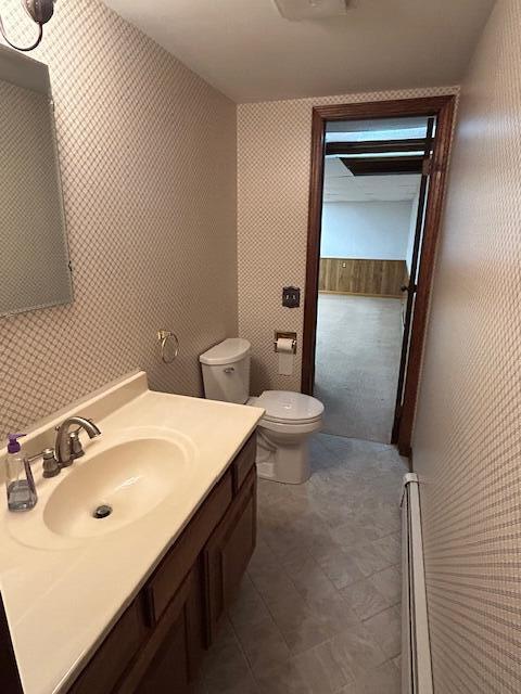 bathroom with vanity, toilet, and a baseboard radiator