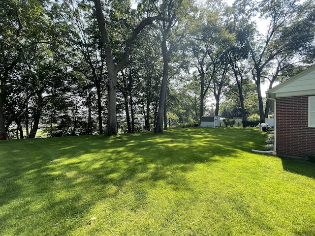 4102 Highgate Rd, Norton Shores, MI 49441 - view of green lawn with a storage shed and an outbuilding