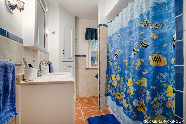 bathroom with curtained shower, crown molding, vanity, and tile walls