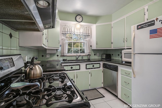 4102 Highgate Rd, Norton Shores, MI 49441 - kitchen featuring appliances with stainless steel finishes, ventilation hood, a sink, decorative backsplash, and dark countertops