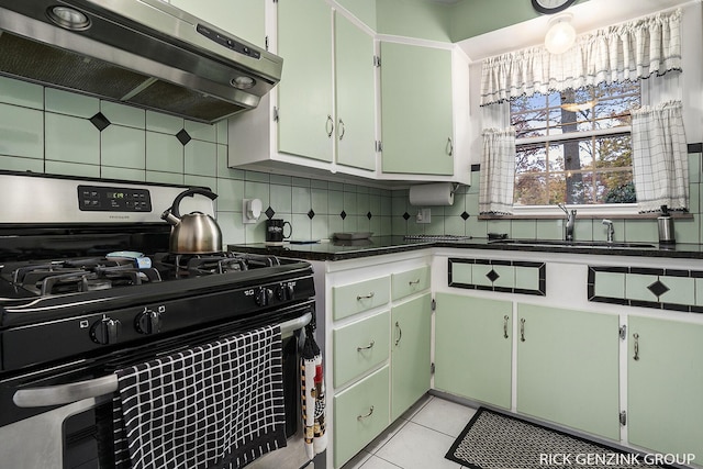 4102 Highgate Rd, Norton Shores, MI 49441 - kitchen featuring appliances with stainless steel finishes, extractor fan, a sink, dark countertops, and decorative backsplash