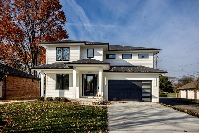 view of front of home with a garage and a front lawn