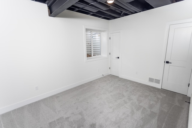 spare room featuring beamed ceiling and carpet