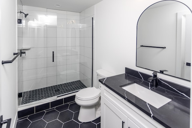 bathroom featuring vanity, a shower with shower door, tile patterned floors, and toilet