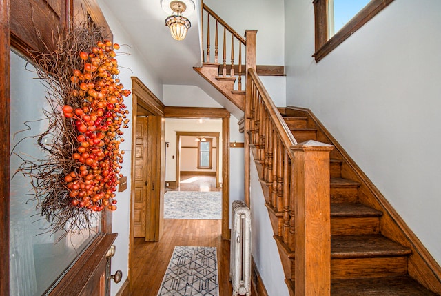 staircase featuring hardwood / wood-style floors and radiator heating unit