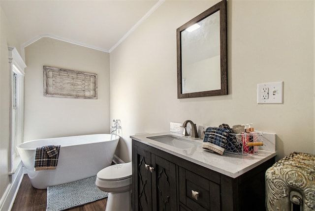 bathroom with wood-type flooring, a tub, toilet, vanity, and ornamental molding