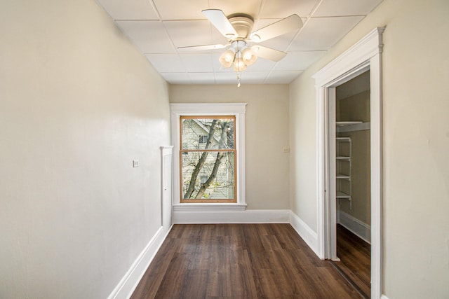 interior space featuring a drop ceiling, dark hardwood / wood-style floors, and ceiling fan