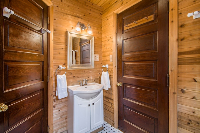 bathroom with vanity and wood walls