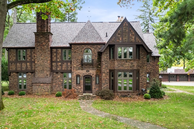 tudor-style house featuring a front lawn