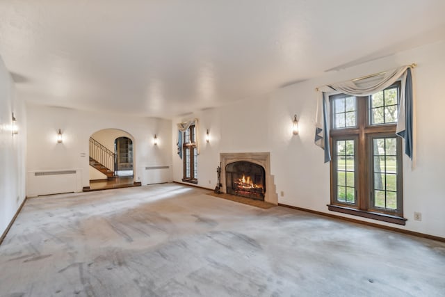 unfurnished living room featuring carpet and radiator heating unit