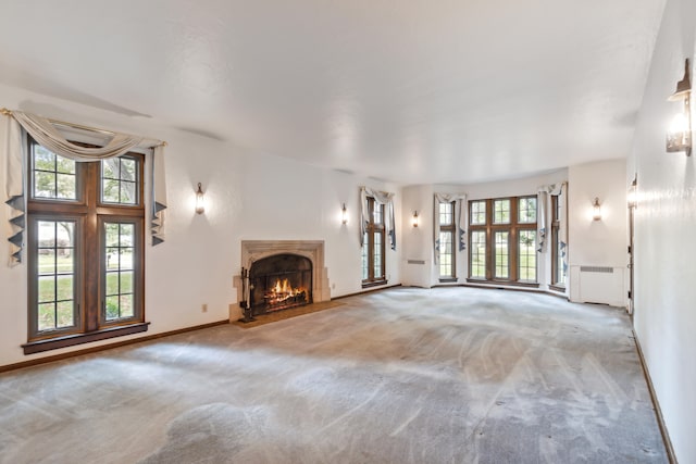 unfurnished living room featuring light carpet and radiator