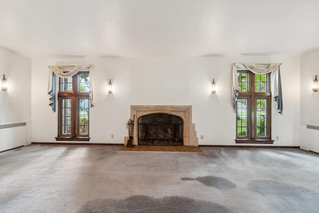 unfurnished living room featuring carpet flooring and radiator heating unit