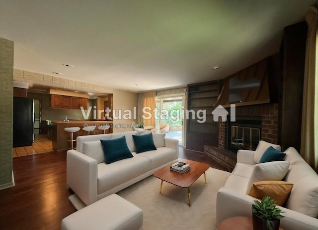 living room featuring wood-type flooring and a brick fireplace