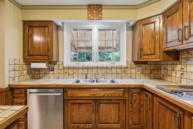 kitchen with tile counters, dishwasher, sink, and backsplash