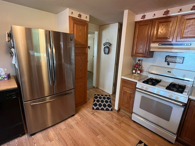 kitchen with dishwasher, gas range gas stove, stainless steel fridge, range hood, and light hardwood / wood-style flooring