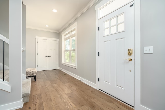 entryway featuring crown molding and light wood-type flooring