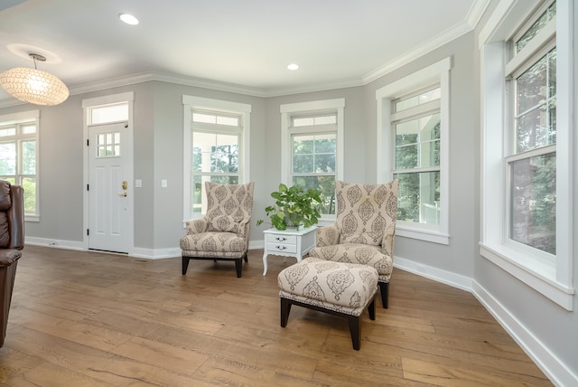 sitting room with light hardwood / wood-style floors and ornamental molding