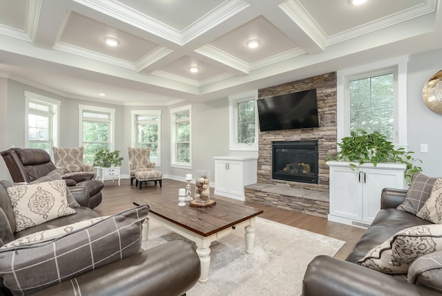 living room featuring coffered ceiling, beamed ceiling, ornamental molding, a fireplace, and light hardwood / wood-style floors