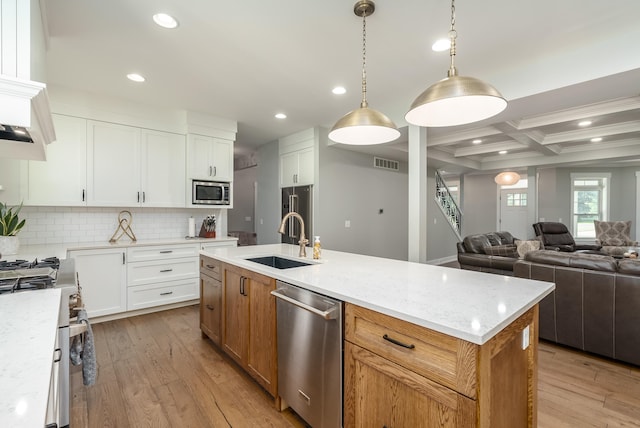 kitchen featuring a kitchen island with sink, stainless steel appliances, sink, white cabinets, and light hardwood / wood-style floors