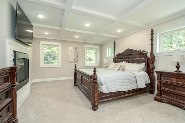 carpeted bedroom featuring a tiled fireplace, coffered ceiling, beamed ceiling, and multiple windows