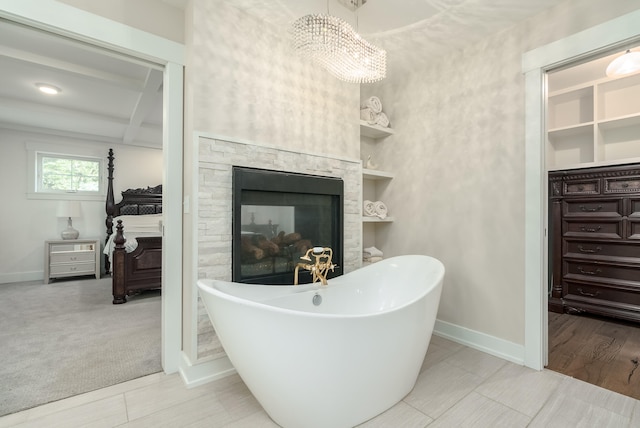 bathroom featuring hardwood / wood-style floors, beamed ceiling, a washtub, vanity, and a multi sided fireplace