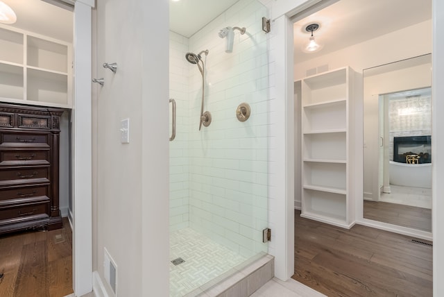 bathroom with hardwood / wood-style floors and a shower with shower door