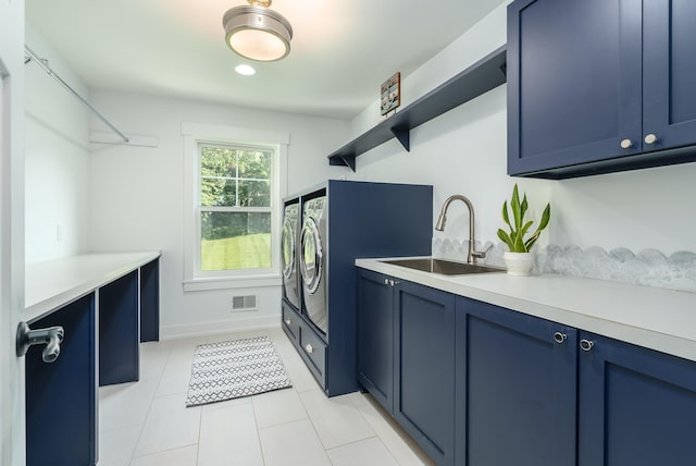 washroom featuring sink, washer and dryer, light tile patterned floors, and cabinets