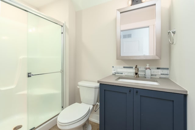 bathroom featuring toilet, vanity, and a shower with door