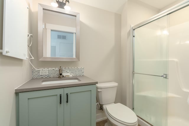 bathroom featuring vanity, toilet, and walk in shower