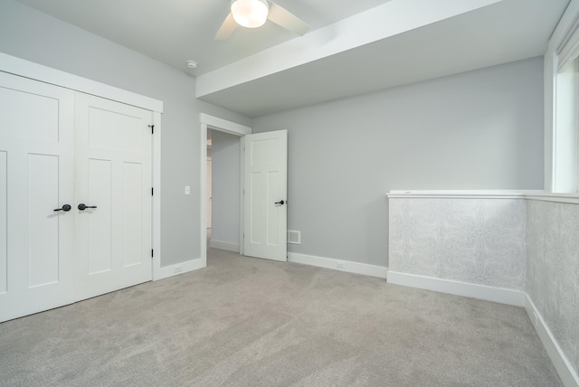 unfurnished bedroom with light carpet, a closet, and ceiling fan