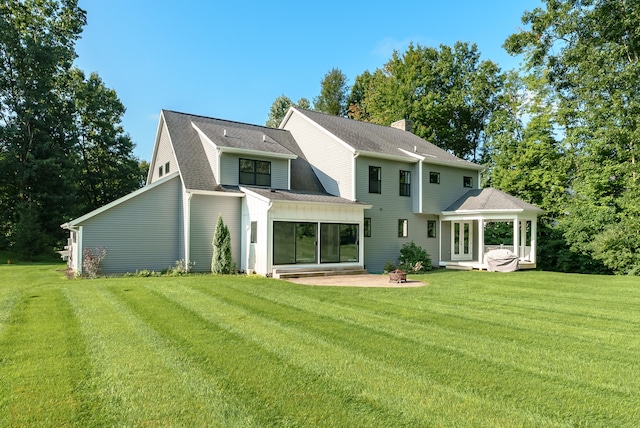 rear view of property featuring a patio area, a gazebo, and a lawn