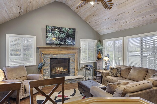 living room with hardwood / wood-style floors, a stone fireplace, lofted ceiling, and wooden ceiling