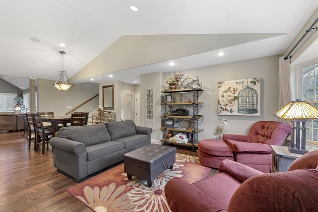 living room with dark hardwood / wood-style flooring, lofted ceiling, and decorative columns