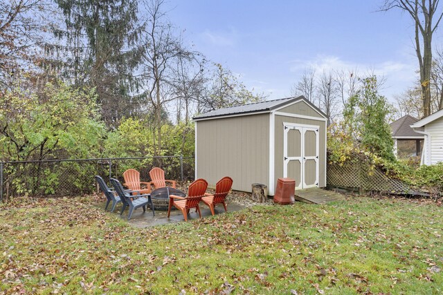 view of outdoor structure featuring a lawn and an outdoor fire pit