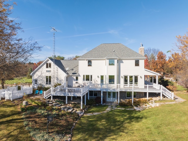 rear view of house with a deck and a lawn