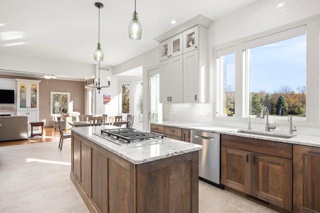 kitchen featuring hanging light fixtures, backsplash, sink, white cabinetry, and appliances with stainless steel finishes