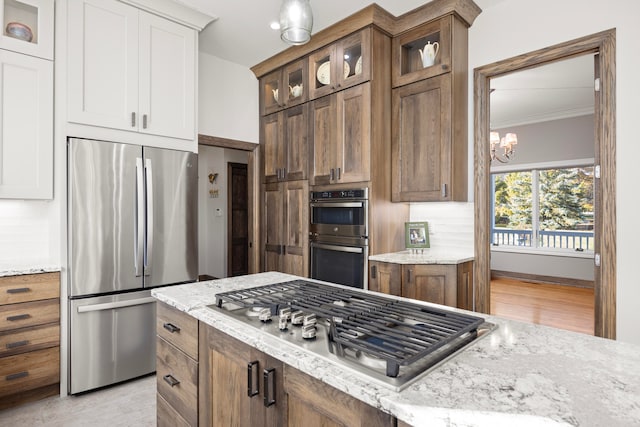 kitchen with ornamental molding, light hardwood / wood-style flooring, white cabinetry, and stainless steel appliances