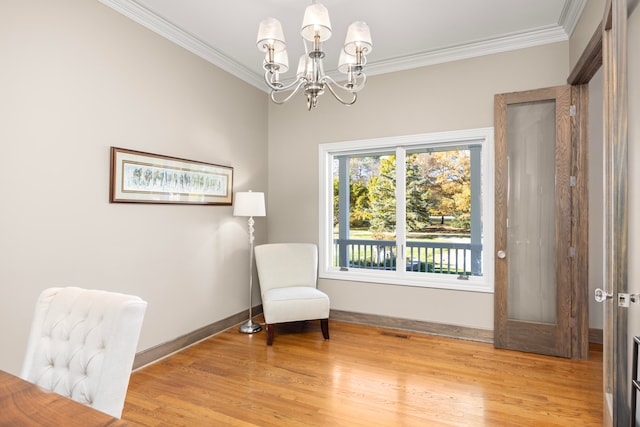 sitting room with light hardwood / wood-style floors, ornamental molding, and a chandelier