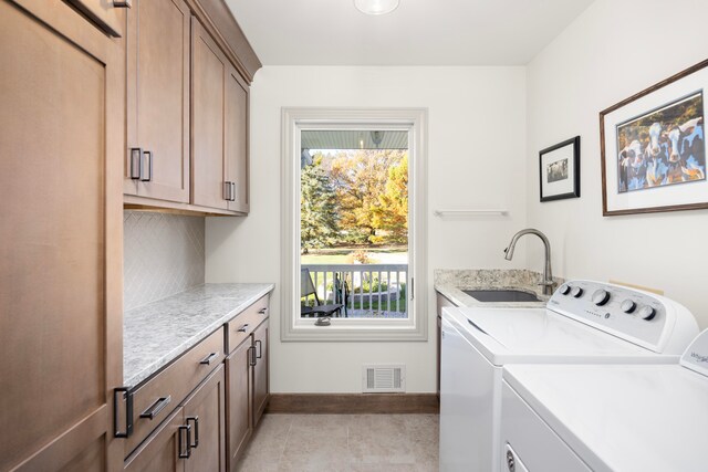 laundry area featuring light tile patterned floors, cabinets, sink, and washing machine and clothes dryer