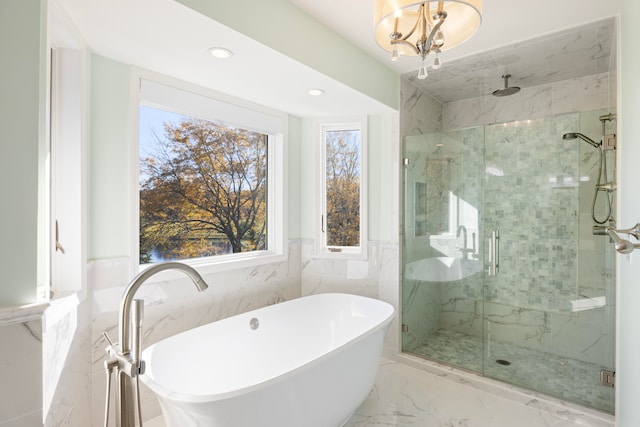 bathroom featuring tile walls, separate shower and tub, and a chandelier