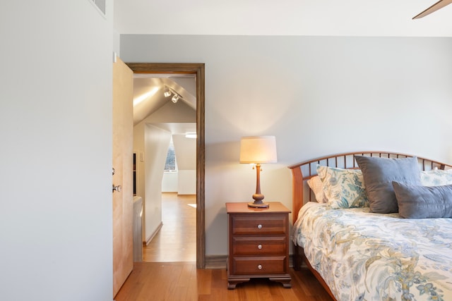 bedroom featuring ceiling fan, lofted ceiling, and light wood-type flooring