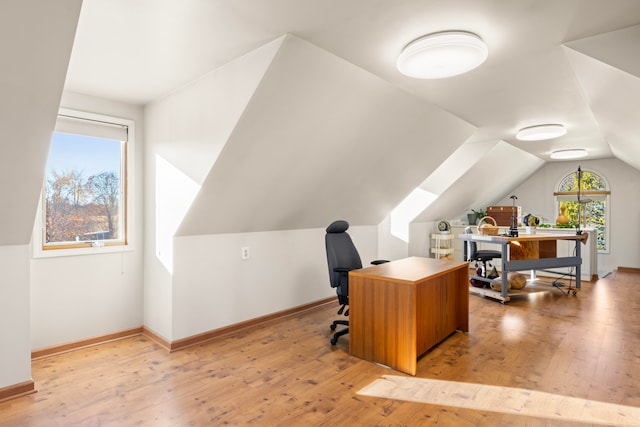 home office with vaulted ceiling and light hardwood / wood-style floors