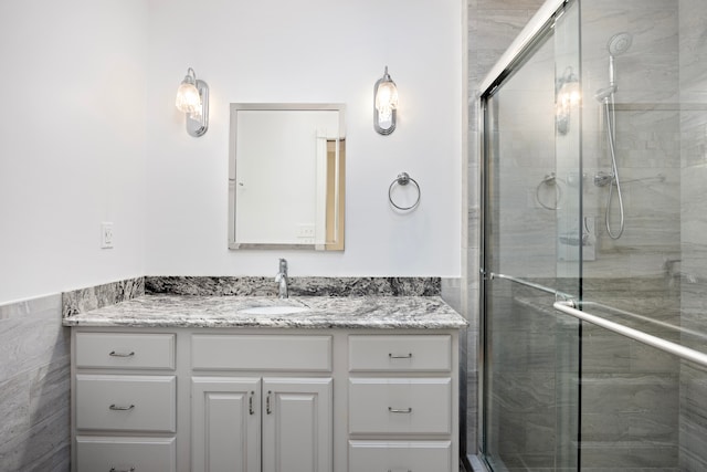 bathroom with vanity and a shower with door