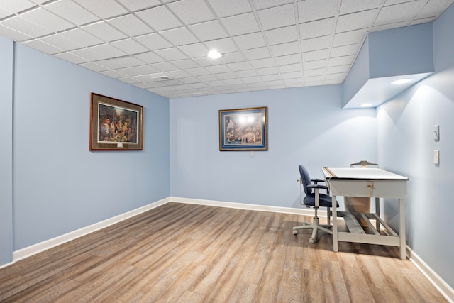 office space featuring a drop ceiling and light hardwood / wood-style flooring