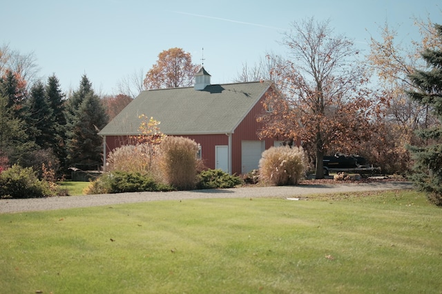 view of property exterior featuring a garage and a lawn