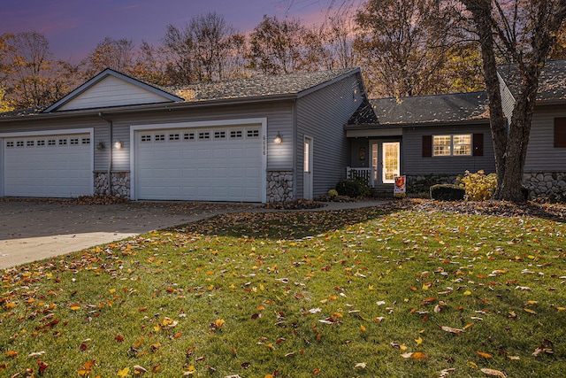 view of front facade with a yard and a garage