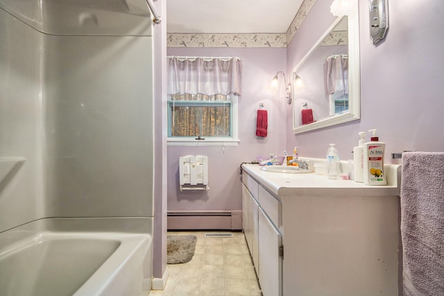 bathroom with vanity, baseboard heating, and a bath