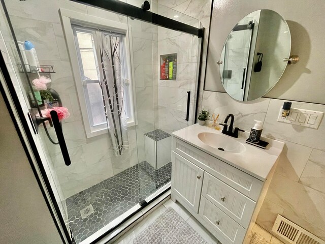 bathroom with vanity, a shower with shower door, and backsplash