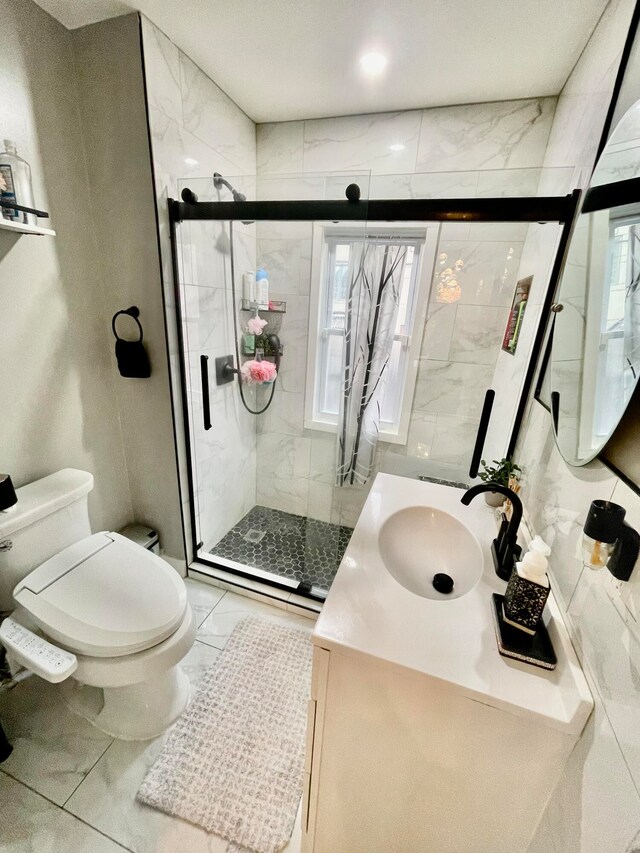 bathroom with a shower with door, vanity, a healthy amount of sunlight, and toilet